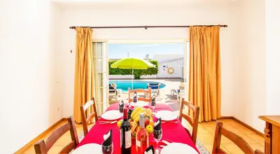 a dining room with a table and a pool at Villa Boracay by Algarve Vacation in Albufeira