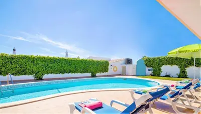 a swimming pool with lounge chairs and an umbrella at Villa Boracay by Algarve Vacation in Albufeira
