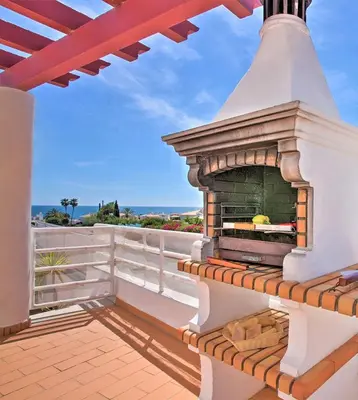 a fireplace on a balcony with the ocean in the background at Villa Melanésia by Algarve Vacation in Guia