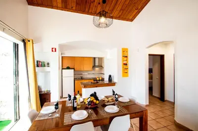 a kitchen and dining room with a wooden table and chairs at Villa Krabi by Algarve Vacation in Albufeira