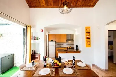 a kitchen and dining room with a wooden table at Villa Krabi by Algarve Vacation in Albufeira