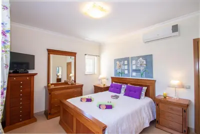 a bedroom with a large bed with purple pillows at Villa Manihi by Algarve Vacation in Albufeira