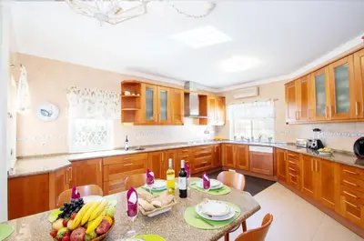 a kitchen with wooden cabinets and a table with fruit on it at Villa Manihi by Algarve Vacation in Albufeira