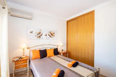 a bedroom with a bed with orange and black pillows at Villa Manihi by Algarve Vacation in Albufeira