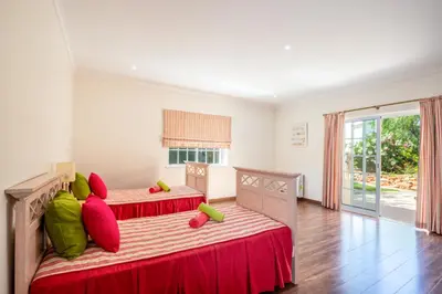 a bedroom with two beds with red and green pillows at Villa Savannah by Algarve Vacation in Almancil