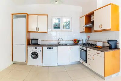 a kitchen with white cabinets and a washer and dryer at Villa Turtle Beach by Algarve Vacation in Albufeira