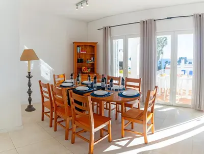 a dining room with a wooden table and chairs at Villa Turtle Beach by Algarve Vacation in Albufeira
