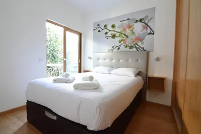 a bedroom with a large white bed with towels on it at Eugenia's House in Faro