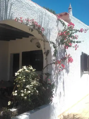 a white house with flowers on the side of it at Alsouk in Vilamoura