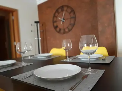 a table with wine glasses and a plate on it at Apartamento Alfarrobeira Mar in Quarteira