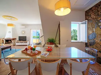 a kitchen and living room with a table and chairs at Holiday Home Casa do Sol by Interhome in Patroves