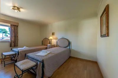 a room with two beds and a table and chairs at Villa with Garden and Pool in Vilamoura