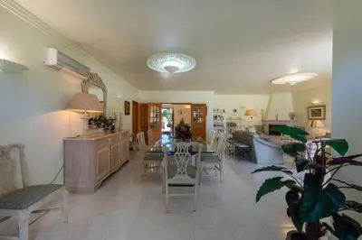 a living room with a table and chairs at Villa with Garden and Pool in Vilamoura