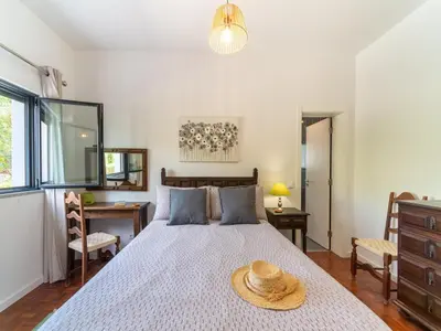 a bedroom with a bed with a straw hat on it at Casa O Sonho near Faro with private pool in Santa Bárbara de Nexe