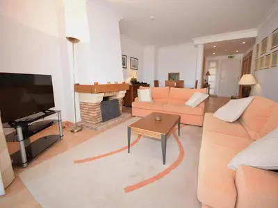 a living room with a couch and a fireplace at Sunny Balcony Apartment and Pool in Vilamoura