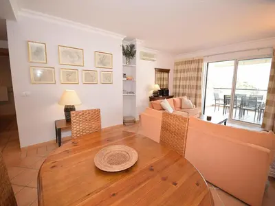 a living room with a table and a couch at Sunny Balcony Apartment and Pool in Vilamoura