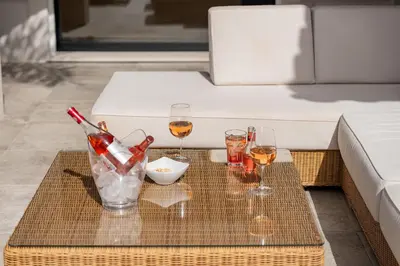 a table with two glasses and wine bottles on it at Villa Coral - Varandas do Lago in Almancil