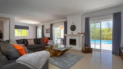 a living room with a couch and a fireplace at Villa Natura - Varandas do Lago in Almancil