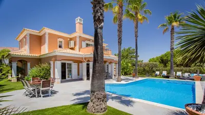 a villa with a swimming pool and palm trees at Villa Natura - Varandas do Lago in Almancil