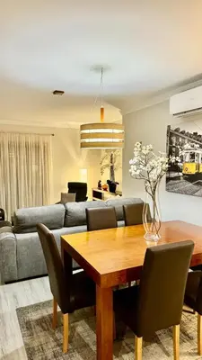 a living room with a table and a couch at Casa Sol Corcovada in Albufeira