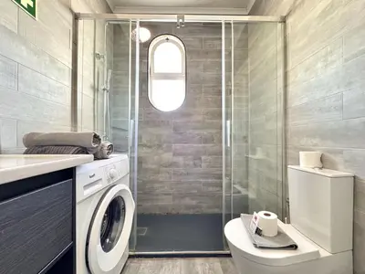 a bathroom with a washing machine and a shower at Albufeira Delight with Pool by Homing in Guia