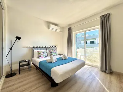a bedroom with a bed and a large window at Albufeira Delight with Pool by Homing in Guia