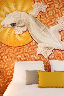a bedroom with a bed with a fish head on the wall at Le Jardin Secret de Faro Guesthouse in Faro