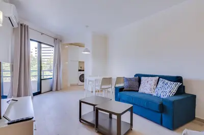 a living room with a blue couch and a table at Tália - City Center - Vilamoura in Vilamoura
