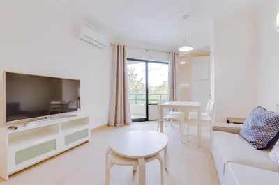 a kitchen with white cabinets and a washer and dryer at Tália - City Center - Vilamoura in Vilamoura