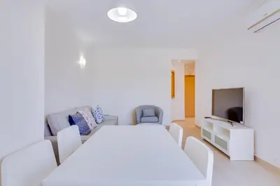 a white room with a white table and chairs at Tália - City Center - Vilamoura in Vilamoura