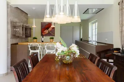 a kitchen and dining room with a wooden table and chairs at Casa Lago in Quinta do Lago