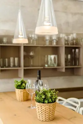 a table with two wine glasses and potted plants at Casa Lago in Quinta do Lago