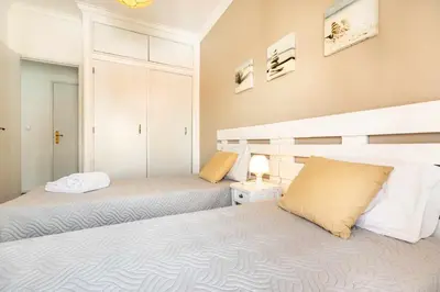 a bedroom with two beds and a night stand at T2 Apartamento do Tenis in Albufeira