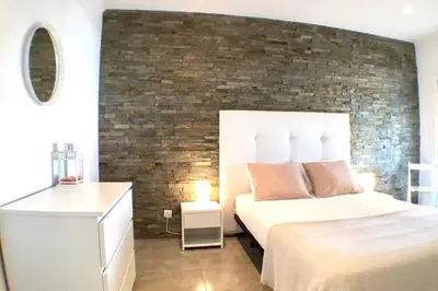 a bedroom with a bed and a brick wall at Edifico Ouramar T2 in Albufeira