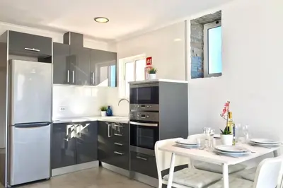 a kitchen with stainless steel appliances and a white table at Edifico Ouramar T2 in Albufeira