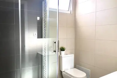 a bathroom with a toilet and a glass shower at Edifico Ouramar T2 in Albufeira