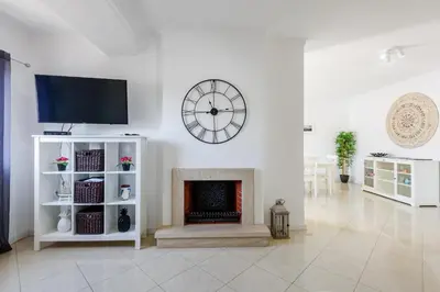a living room with a fireplace and a clock on the wall at Amazing apartment in Albufeira in Albufeira