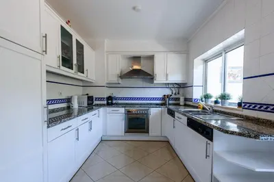 a large white kitchen with white cabinets and appliances at Amazing apartment in Albufeira in Albufeira