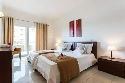 a bedroom with a large bed and a desk and a bed at Quinta Barracuda in Albufeira