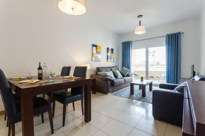 a living room with a dining table and a couch at Quinta Barracuda in Albufeira