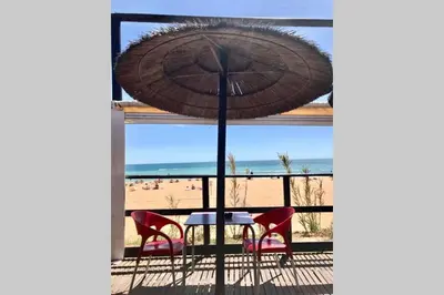 a table with chairs and an umbrella in front of a beach at Quinta Barracuda in Albufeira