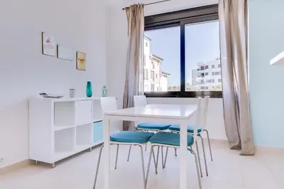 a white table and chairs in a room with a window at Cruzeiro do Sul Apartments - Vilamoura center in Vilamoura