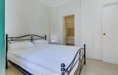 a bedroom with a large bed with white sheets at Faro Tradicional House - City center in Faro