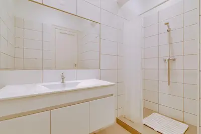 a white bathroom with a sink and a mirror at Faro Tradicional House - City center in Faro