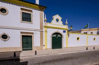 a church with two green doors on a street at Faro Tradicional House - City center in Faro