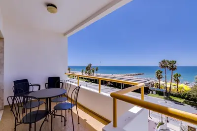a balcony with tables and chairs and a view of the ocean at York - Sea view - Quarteira in Quarteira
