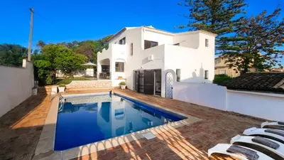 a swimming pool in front of a white house at El Gharbe by Check-in Portugal in Albufeira