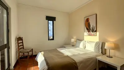 a bedroom with a bed and a table and a window at El Gharbe by Check-in Portugal in Albufeira