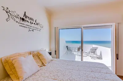a bedroom with a bed and a view of the ocean at Sky - wonderful view to the beach - Quarteira in Quarteira