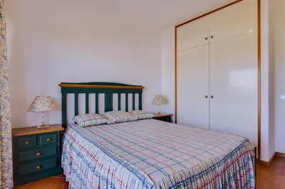 a bedroom with a bed and a dresser at Village Atlântico Apartment in Vilamoura
